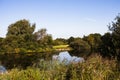 Small quiet lake surrounded by green trees.