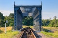 Small railway bridge in countryside at sunny summer morning against blue sky and green trees. Nature landscape Royalty Free Stock Photo