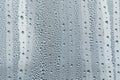 A small raindrop rests on the glass after rain. Raindrops On The Glass. Raindrops on the window. Blue tone. Abstract background.