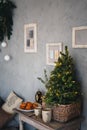 Small real christmas tree with yellow christmas lights, loft style modern design room in light colors decorated for Royalty Free Stock Photo