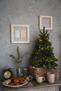 Small real christmas tree with yellow christmas lights, loft style modern design room in light colors decorated for Royalty Free Stock Photo