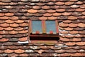 Small rectangle roof window with broken safety glass mounted with rusted cracked metal frame on old dilapidated roof tiles Royalty Free Stock Photo