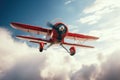 A small red airplane soaring through a cloudy sky. Perfect for aviation enthusiasts and travel-related designs Royalty Free Stock Photo