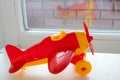 A small red airplane-a trinket-stands on the window. Plastic toys isolated on a white background Royalty Free Stock Photo