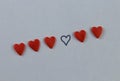 Small red and black hearts on a blue background in a row Royalty Free Stock Photo