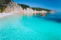 Small Red Boat On Clear Blue Sea Water Near To Amazing Beach On Mediterranean Island. Summer Beach Vacation Relaxation Concept