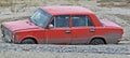 A small red car stuck in the coastal sand. Royalty Free Stock Photo