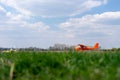 Small red charter airplane waiting on a green field to take off Royalty Free Stock Photo