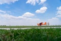 Small red charter airplane waiting on a green field to take off Royalty Free Stock Photo