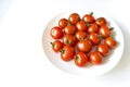 Small red cherry tomatoes on a plate in a group