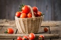 Small red cherry tomatoes in a small wicker basket Royalty Free Stock Photo