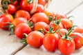 Small red cherry tomatoes spill out of a wicker basket. Royalty Free Stock Photo