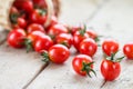 Small red cherry tomatoes spill out of a wicker basket Royalty Free Stock Photo