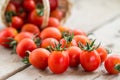 Small red cherry tomatoes spill out of a wicker basket. Royalty Free Stock Photo