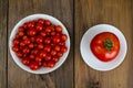 Small red cherry tomatoes in white bowl on wooden background Royalty Free Stock Photo