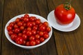 Small red cherry tomatoes in white bowl on wooden background Royalty Free Stock Photo