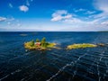 A small red cottage on an island in the blue sea on a summer day. Finland. View from above. Royalty Free Stock Photo