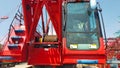 Small red crawler crane operator cabin boom anchor drum and side machine crane front look