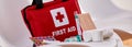 Small red First Aid kit with pills and bandages