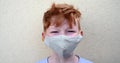 Red hair aryan blue eyes boy with freckles wearing protective face mask during coronavirus pandemic, detail posing for camer