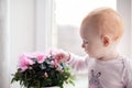 A small red-haired girl sits on the windowsill Royalty Free Stock Photo