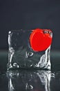 small red heart frozen in an ice cube. Melting ice, water