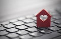 Small red house with heart over keyboard Royalty Free Stock Photo