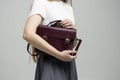 Small red leather bag in a woman& x27;s hand on a white background. Shoulder handbag. Woman in a white shirt and grey skirt Royalty Free Stock Photo