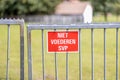 Small red metal sign on a metal gate at a horse farm that says: `NIET BETREDEN SVP` = `DO NOT FEED PLEASE