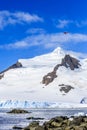 Small red plane flying over snow peaks, glaciers and sea fjord, Royalty Free Stock Photo