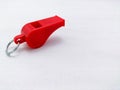 A small red plastic whistle on white background Royalty Free Stock Photo