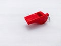 A small red plastic whistle on white background Royalty Free Stock Photo