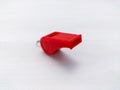A small red plastic whistle on white background Royalty Free Stock Photo