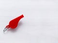 A small red plastic whistle on white background Royalty Free Stock Photo