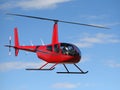 Small red rescue helicopter flying in blue sky. Royalty Free Stock Photo