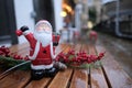 Small red santa figurine standing on a table of a coffee shop, wet from every day rains in the united kingdom. Christmas period is