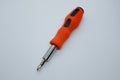 Small red screwdriver, isolated on the gray white background. Royalty Free Stock Photo