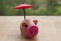 Small red umbrella over piggy bank on wooden table. Investment concept. Royalty Free Stock Photo