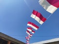 Small red and white flags against a blue sky background. Indonesian independence day celebration. Royalty Free Stock Photo