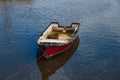 A small red and white wooden rowing boat in a Cornish harbour Royalty Free Stock Photo