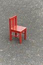 Small red wooden child chair on the street