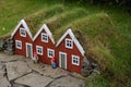 Small red wooden house with grass on the roof and gnomes figurines Royalty Free Stock Photo