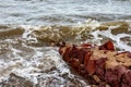 Small reddish brown irregular stone wall on beach Royalty Free Stock Photo