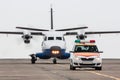 A small regional turboprop aircraft run the follow-me-car along the airport apron Royalty Free Stock Photo