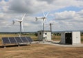 A small renewable energy installation in a rural landscape features two wind turbines and an array Royalty Free Stock Photo