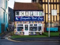 a small restaurant on the corner of a street in front of some colorful buildings