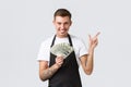 Small retail business, payments and employees concept. Handsome determined happy waiter, barista pointing finger right
