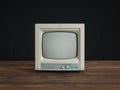 Small retro monitor on a wooden table on a black background.