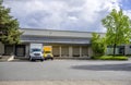 Small rigs semi trucks with box trailers standing in warehouse dock for loading cargo for delivery Royalty Free Stock Photo