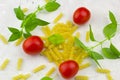 Small ripe tomatoes, fresh basil ,pasta top view Royalty Free Stock Photo